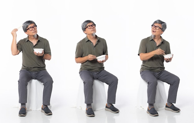 Pełna długość 50s 60s azjatycki chiński właściciel sklepu mężczyzna jedzący jedzenie pałeczka do jedzenia miska