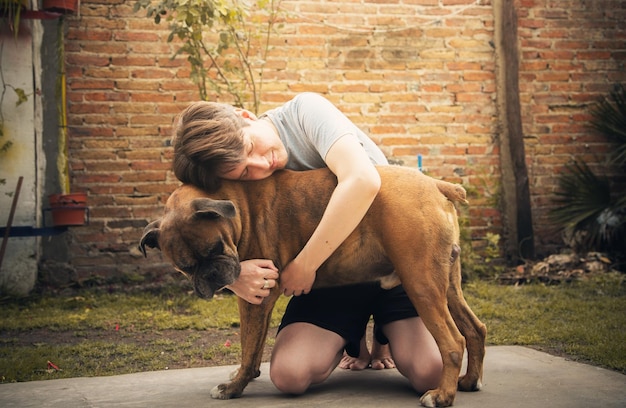 Zdjęcie pełna długość człowieka 8 uściskającego psa na podwórku