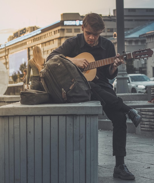 Zdjęcie pełna długość człowieka grającego na gitarze