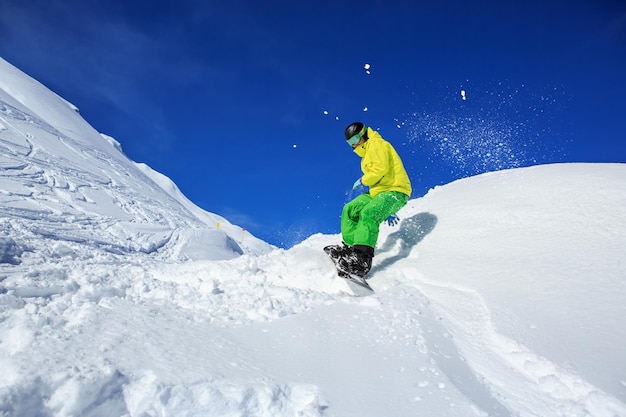 Pełna długość człowieka snowboarding na śnieżnej górze przeciwko niebu