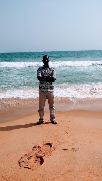 Zdjęcie pełna długość człowieka stojącego na plaży