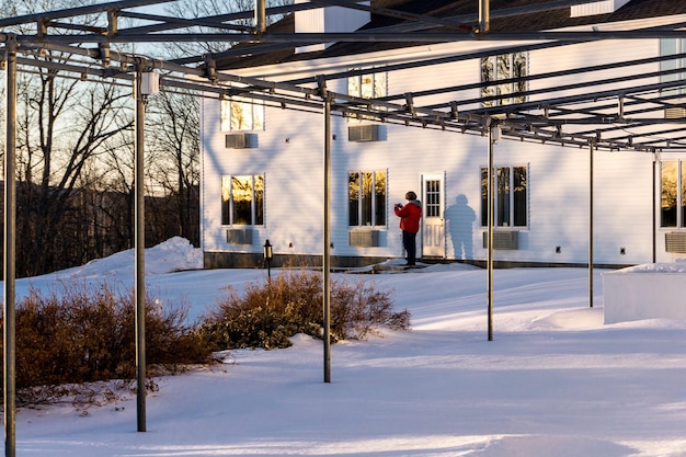 Zdjęcie pełna długość człowieka stojącego przy domu w zimie