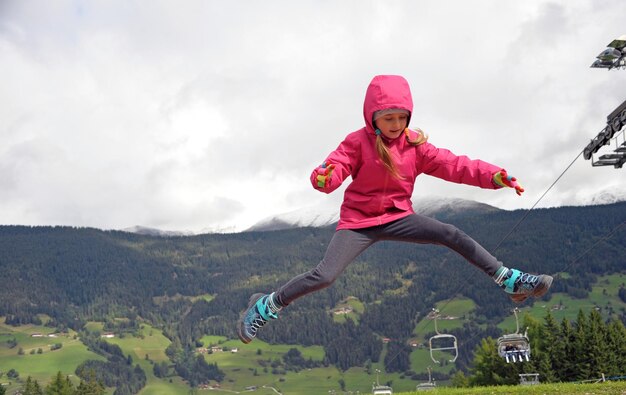 Zdjęcie pełna długość dziewczyny skaczącej na góry i niebo