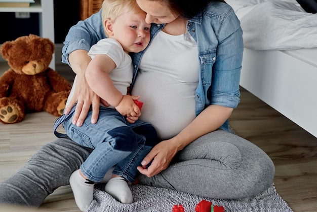 Zdjęcie pełna długość matki i dziecka siedzących w domu