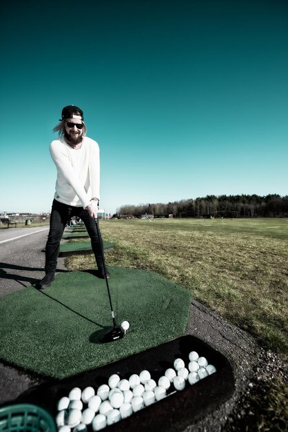 Zdjęcie pełna długość szczęśliwego dorosłego mężczyzny grającego w golfa