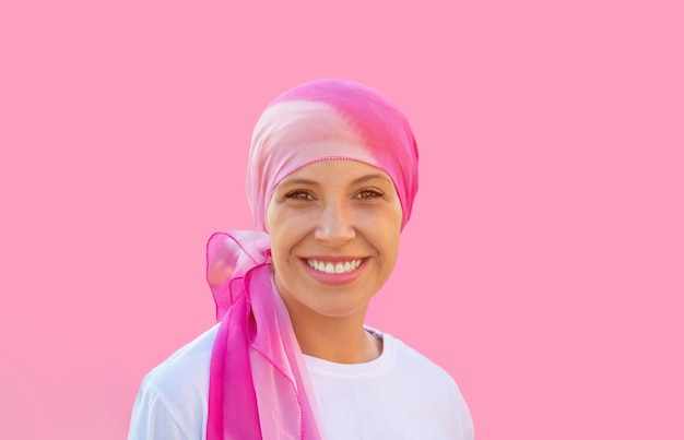 Pełna nadziei kobieta nosząca chustę na różowym tle