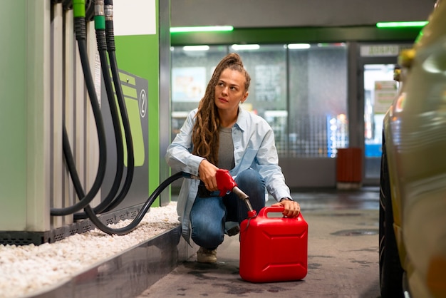 Pełne ujęcie kobiety na stacji benzynowej