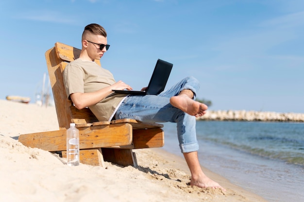 Zdjęcie pełne ujęcie koczownika pracującego na plaży