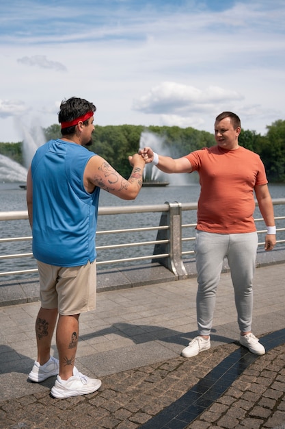 Pełne ujęcie mężczyzn ćwiczących razem na świeżym powietrzu