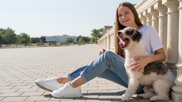 Zdjęcie pełne ujęcie uśmiechnięta dziewczyna trzyma ładny pies