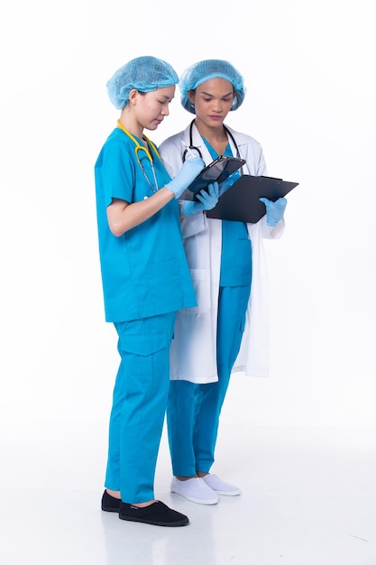 Pełnej długości profesjonalny lekarz lekarz stoją w mundurze szpitalnym omówić stan wykresu pacjenta na tablecie kobieta praktykujący nosić płaszcz pewnie w klinice na białym tle