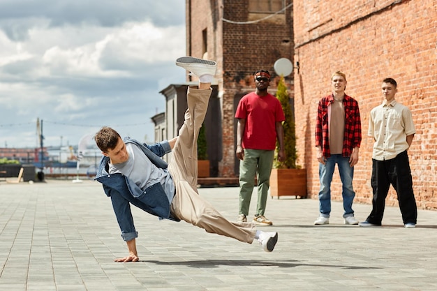 Pełnej długości ujęcie ruchu męskiego zespołu breakdance występującego na zewnątrz oświetlonego światłem słonecznym miejsca kopiowania