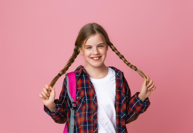 Pełnej Długości Uśmiechnięta Mała Uczennica 1013 Lat W Przypadkowych Dżinsowych Ubraniach Z Plecakiem Odizolowanym Na Różowym Tle Portret Studyjny Koncepcja Edukacji Dzieci