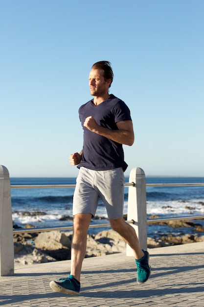 Pełny długość sportów mężczyzna jogging outside morzem