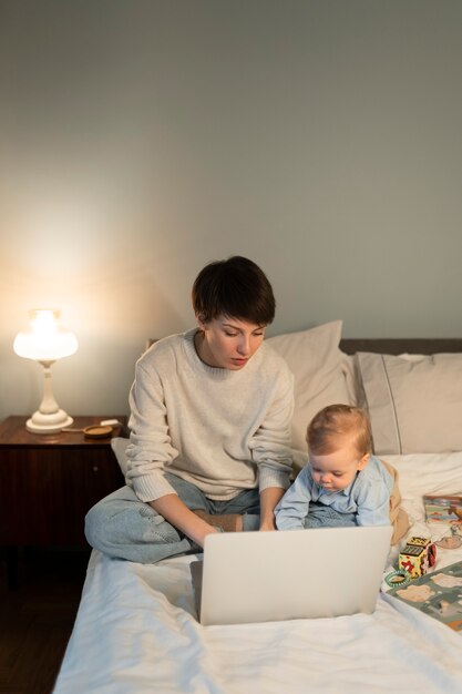 Zdjęcie pełny strzał mama i dziecko w łóżku