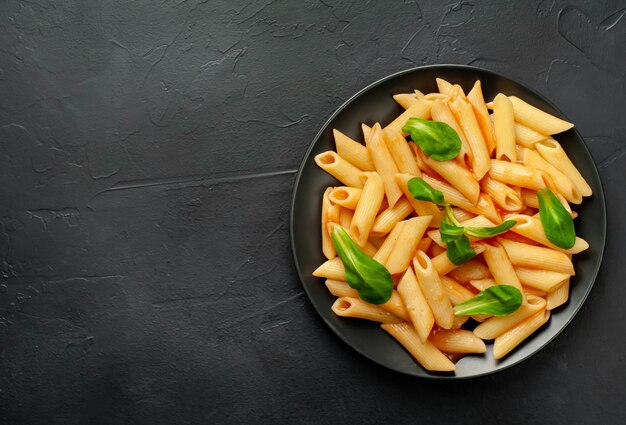 Penne makaron w talerzu na betonowym tle