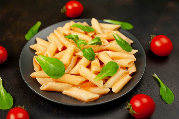 Penne makaron w talerzu na drewnianym tle