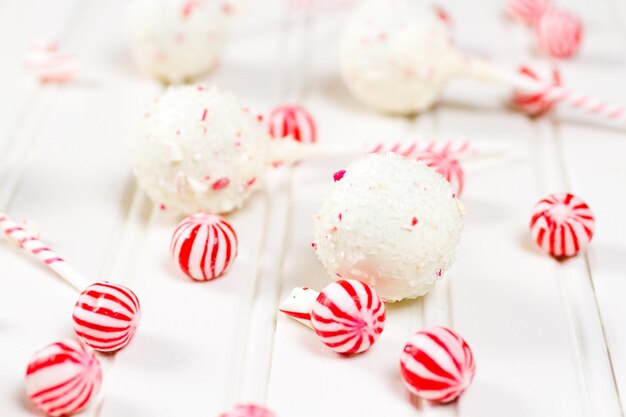 Peppermint chocolate cake pops zanurzony w białej czekoladzie i kawałkach trzciny cukrowej.