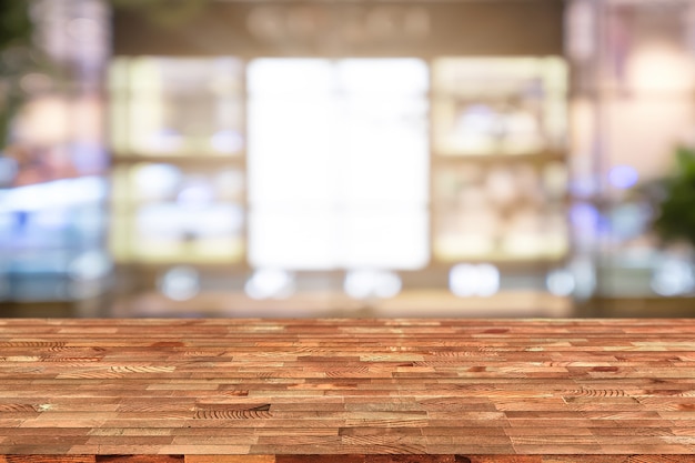 Perspektywa drewniany stół na wierzchu nad plamy sklep z kawą tłem, może być używać egzamin próbny up.