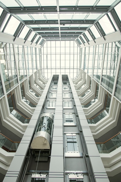 Perspektywa lobby biurowego: zaokrąglony dach i przeszklone ściany w nowoczesnym holu z windą