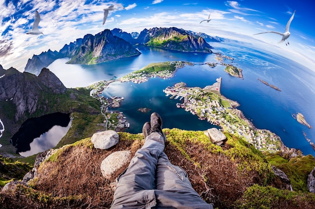 Perspektywa Pierwszej Osoby Sfotografowana Z Turysty Siedzącego Na Krawędzi Klifu Na Lofotach To Archipelag W Hrabstwie Nordland W Norwegii. Soczewka 'rybie Oko.