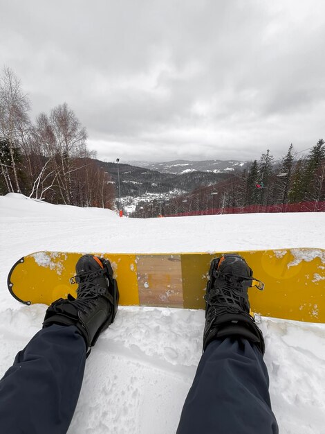 Zdjęcie perspektywa snowboarda z pokrytych śniegiem gór i zbocza niebo jest chmurne i białe dające uczucie spokoju