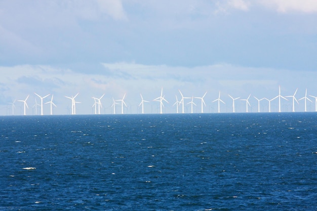 Perspektywiczna linia wiatraków oceanicznych z ciemną wodą i niebem