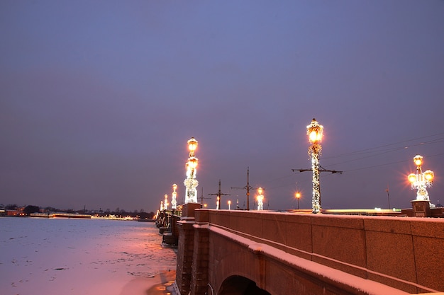 Petersburg w dekoracjach na Nowy Rok i Boże Narodzenie, most z płonącymi latarniami nad Newą.