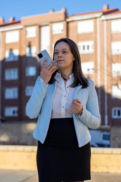 Pewna siebie młoda bizneswoman korzystająca z funkcji rozpoznawania głosu na smartfonie Nowoczesna przedsiębiorczyni na zewnątrz wysyłająca wiadomość głosową za pośrednictwem komunikatora internetowego Portret pionowy