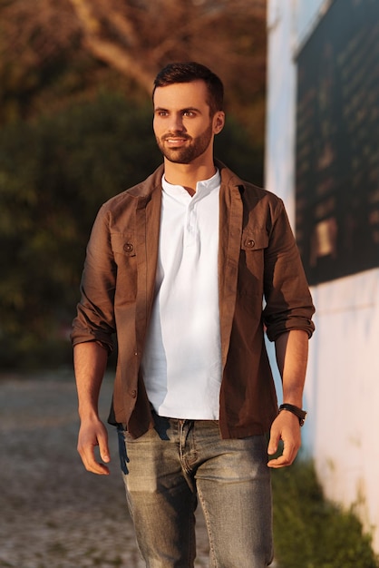 Zdjęcie pewnie uśmiechnięty turecki facet stojący na ścieżce w parku