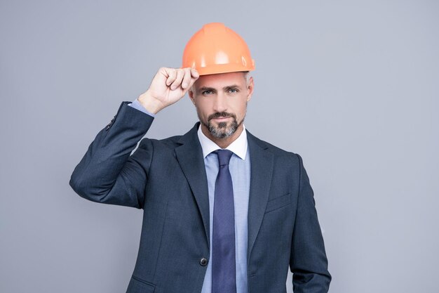 Pewny siebie biznesmen w formalwear. biznes bezpieczeństwa. człowiek sukcesu z gestem powitania. przedsiębiorca w kasku. główny inżynier architekt. zawodowy inżynier w kasku.