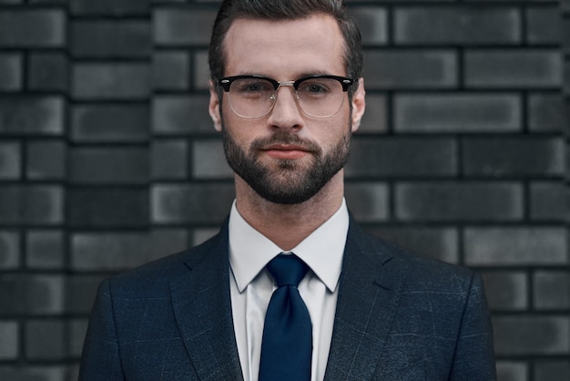 Pewny widok lidera młodego biznesmena w okularach i z brodą