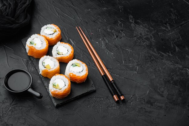 Philadelphia roll sushi z łososiem, krewetką, awokado, serkiem śmietankowym, na czarnym kamieniu