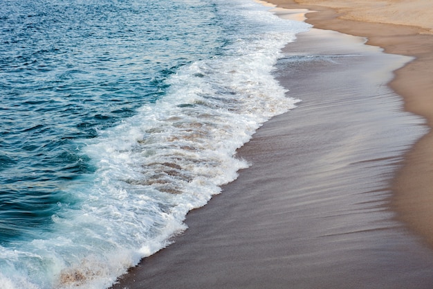 Piankowe fale pękające na plaży