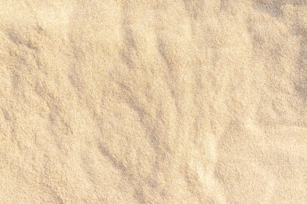 Zdjęcie piasek tekstura tło na plaży. jasnobeżowy wzór tekstury piasku morze, tło piaszczystej plaży.