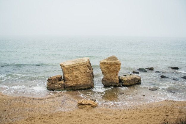 Piaskowe skały na plaży na tle morza