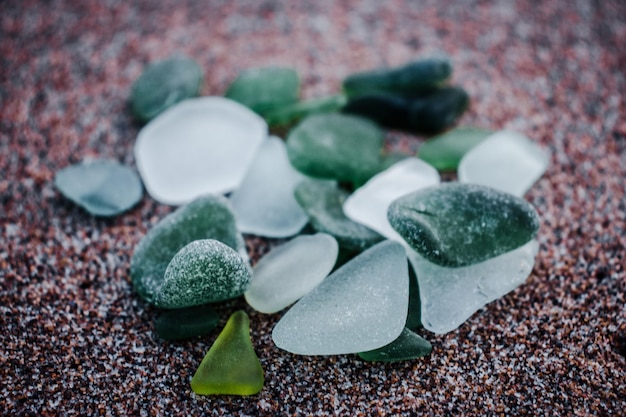 Zdjęcie piaszczysta plaża i szklane kamienie zdjęcie koncepcyjne szklane kamienie ze złamanych butelek polerowanych przez morze