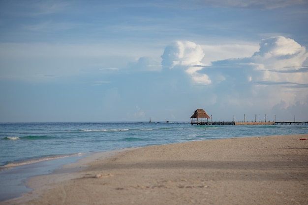 Zdjęcie piaszczysta plaża na morzu karaibskim z azurową wodą i chałupą na horyzoncie