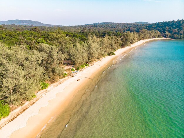 Piaszczysta plaża widok z góry z lotu ptaka pięknej piaszczystej plaży z lotu ptaka z niebieskimi falami toczącymi się na brzeg, niektóre skały są obecne