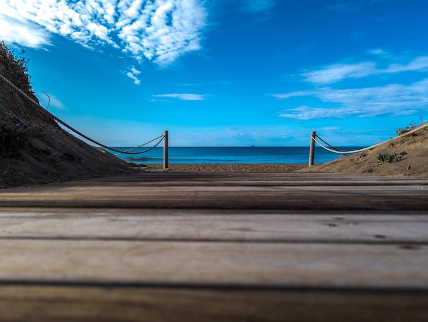 Piaszczysta plaża z promenadą pod niebieskim niebem w słoneczny dzień