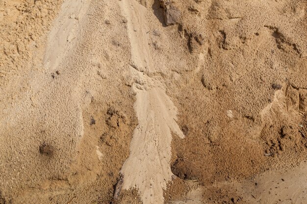 Piaszczysta plaża z wzorami ze strumieni wody Tekstura piaszczystej powierzchni po