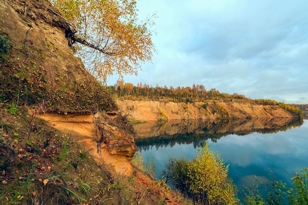 Piaszczysty brzeg górskiego jeziora w regionie leningradzkim jesienią.