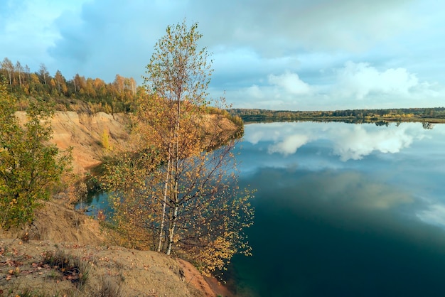 Piaszczysty brzeg górskiego jeziora w regionie leningradzkim jesienią.