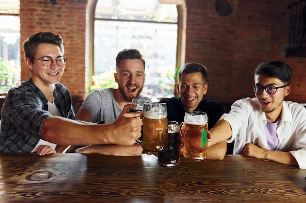 Picie piwa Ludzie w zwykłych ubraniach siedzący w pubie