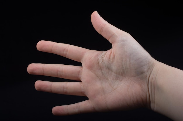 Pięć palców ludzkiej dłoni częściowo widocznych w widoku