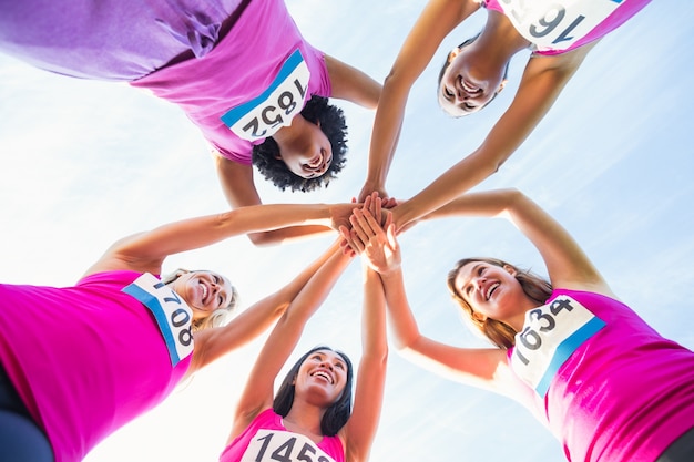 Zdjęcie pięć uśmiechniętych biegaczy wspierających maraton raka piersi