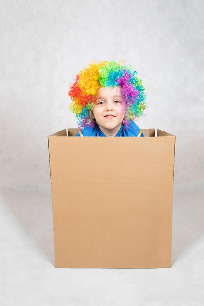 Pięcioletni chłopiec ubrany w kostium klauna zostaje w kartonowym pudełku papierowym. Zbliżenie