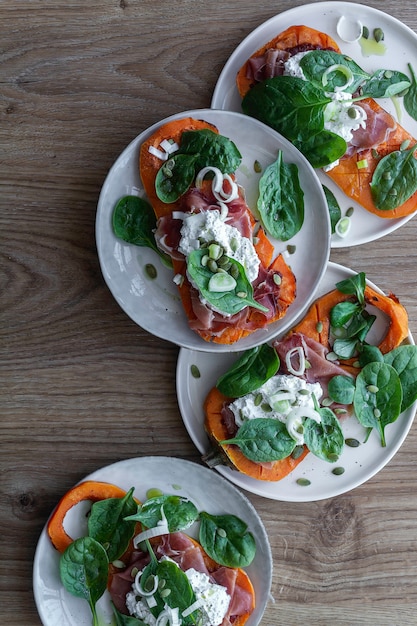 Zdjęcie pieczona dynia z serem ricotta, szynką serrano, szpinakiem i cebulą