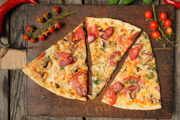 Pieczona pizza z wędzonymi kiełbasami, pieczarkami, pomidorami, serem i koperkiem