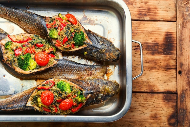 Pieczona ryba faszerowana brokułami i quinoa. Pieczona ryba z warzywami na tacy